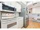 Bright kitchen with stainless steel appliances, white cabinets, and laminate wood flooring at 12200 Vonn Rd # 6D, Largo, FL 33774