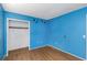 Bright blue bedroom featuring wood floors, closet and playful decor at 12704 128Th Ln, Largo, FL 33774