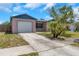 Cozy home features a one-car garage and a simple, well-maintained front yard at 12704 128Th Ln, Largo, FL 33774