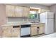 Compact kitchen featuring laminate countertops and essential appliances at 12704 128Th Ln, Largo, FL 33774