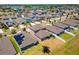 Neighborhood aerial view showing well-maintained homes with solar panels and manicured lawns in a Gathering-friendly community at 14618 Scottburgh Glen Dr, Wimauma, FL 33598