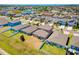 Aerial view of a residential neighborhood with well-maintained lawns and blue, beige, and lilac colored homes at 14618 Scottburgh Glen Dr, Wimauma, FL 33598