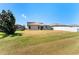 Spacious backyard with green grass and a modern home with an outdoor patio, ideal for relaxation at 14618 Scottburgh Glen Dr, Wimauma, FL 33598