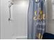 Bright bathroom featuring a shower with white tiled walls and a cheerful curtain at 14618 Scottburgh Glen Dr, Wimauma, FL 33598