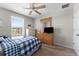 Bright bedroom featuring a window, closet, ceiling fan and comfortable-looking bed with a blue plaid comforter at 14618 Scottburgh Glen Dr, Wimauma, FL 33598