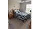 Neutral toned bedroom features a window, ceiling fan, and a bed with blue and white bedding at 14618 Scottburgh Glen Dr, Wimauma, FL 33598