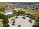 Aerial view of community amenities, including a pool, parking, playground, tennis courts, and landscaping at 14618 Scottburgh Glen Dr, Wimauma, FL 33598