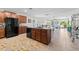 Open-concept kitchen with a central island, dark appliances, and an adjacent living space at 14618 Scottburgh Glen Dr, Wimauma, FL 33598
