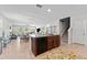Open kitchen with tile floor, large island with a breakfast bar, and view of the living area at 14618 Scottburgh Glen Dr, Wimauma, FL 33598