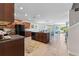 Open concept kitchen with island, tile floor, and black appliances leading into the living area at 14618 Scottburgh Glen Dr, Wimauma, FL 33598