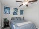 Bright bedroom featuring a comfortable bed, a ceiling fan, stylish wall art, and a window at 15613 Charr Island St, Sun City Center, FL 33573