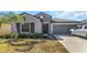 Charming single-story home featuring a well-manicured lawn, inviting entrance, and attached two-car garage at 15613 Charr Island St, Sun City Center, FL 33573