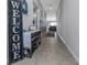 Inviting hallway features tiled floors, a wooden bench, and a 'Welcome' sign, leading to the living area at 15613 Charr Island St, Sun City Center, FL 33573