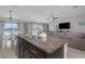 Spacious open-concept with dark cabinets, granite counters and stainless appliances overlooking the water at 15613 Charr Island St, Sun City Center, FL 33573