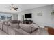 Open-concept living room featuring a large gray sectional sofa with water views at 15613 Charr Island St, Sun City Center, FL 33573