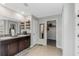 Well-lit bathroom with double sinks, granite countertops, and access to a walk-in closet at 15613 Charr Island St, Sun City Center, FL 33573