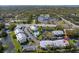 Aerial view of a condo community with a pool, ponds, landscaping, parking, and nearby commercial and residential areas at 2087 Hunters Glen Dr # 126, Dunedin, FL 34698