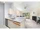 Open kitchen with breakfast bar, stainless steel dishwasher, sink, and open sightlines to the living room and fireplace at 2087 Hunters Glen Dr # 126, Dunedin, FL 34698