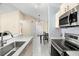 A well-lit kitchen with stainless steel appliances, light countertops, and views of the dining and entry areas at 2087 Hunters Glen Dr # 126, Dunedin, FL 34698
