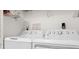 Functional laundry room with white washer and dryer, plus wire shelving at 2087 Hunters Glen Dr # 126, Dunedin, FL 34698