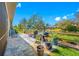 Relaxing back patio with outdoor seating, grilling area, lush landscaping, and serene water views at 2270 Spring Lake Ct, Clearwater, FL 33763