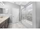 Bright bathroom features a modern shower with marble tile surround and a dark vanity with light countertop at 2270 Spring Lake Ct, Clearwater, FL 33763