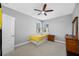 Inviting bedroom features a ceiling fan, a window with blinds and a twin bed with a yellow blanket at 2270 Spring Lake Ct, Clearwater, FL 33763