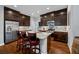 Modern kitchen island featuring dark wood cabinets, stainless steel appliances, and a bar seating for three people at 2270 Spring Lake Ct, Clearwater, FL 33763