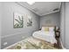 Bedroom showcasing a queen-size bed with a white comforter and leafy artwork on gray walls at 2401 Bayshore Blvd # Cu1, Tampa, FL 33629