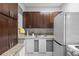 Kitchenette with dark wood cabinets, light granite countertops, and a stainless-steel sink at 2401 Bayshore Blvd # Cu1, Tampa, FL 33629