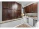Kitchenette with dark wood cabinets, light granite countertops, and a stainless-steel sink at 2401 Bayshore Blvd # Cu1, Tampa, FL 33629