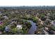 A breathtaking aerial view of a serene neighborhood featuring a calm lake and mature trees at 2633 N Dundee St, Tampa, FL 33629