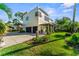 Beautiful home exterior with a well-manicured lawn, dark garage doors, and elegant landscaping at 2633 N Dundee St, Tampa, FL 33629
