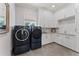 Well-lit laundry room with modern appliances, white cabinetry, and a sleek countertop at 2633 N Dundee St, Tampa, FL 33629