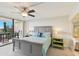Comfortable bedroom with a ceiling fan, balcony, and stylish bedside tables with lamps at 2700 Bayshore Blvd # 9404, Dunedin, FL 34698