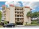 Multi-story condo with balconies, covered parking, and mature palms in lush landscaping at 2700 Bayshore Blvd # 9404, Dunedin, FL 34698