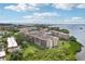 Exterior aerial view of multi-story condos surrounded by lush greenery near a bay at 2700 Bayshore Blvd # 9404, Dunedin, FL 34698