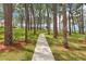 Beautiful community grounds with mature trees, green grass, and a walking path on a sunny day at 2700 Bayshore Blvd # 9404, Dunedin, FL 34698
