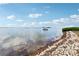 Scenic view of the bay with a boat anchored on the water and rocks along the shoreline at 2700 Bayshore Blvd # 9404, Dunedin, FL 34698