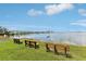Three wooden benches sit on the green lawn offering waterfront views at 2700 Bayshore Blvd # 9404, Dunedin, FL 34698