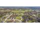 A bird's-eye view displays a home nestled in a verdant neighborhood, complete with mature trees and manicured lawns at 27941 Austin Woods Dr, Dade City, FL 33525