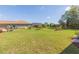 Expansive backyard with lush green lawn, a screened-in lanai, and mature landscaping at 27941 Austin Woods Dr, Dade City, FL 33525