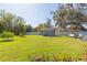 Expansive backyard featuring a large shed and a well-maintained lawn, perfect for outdoor activities at 27941 Austin Woods Dr, Dade City, FL 33525