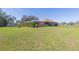 Exterior view of a home featuring a screened-in lanai, lush greenery, and ample outdoor space at 27941 Austin Woods Dr, Dade City, FL 33525