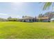 Expansive green lawn with a charming exterior view of the home, including a well-manicured yard at 27941 Austin Woods Dr, Dade City, FL 33525