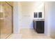 Bright bathroom features tiled shower with glass door and a vanity with dark wood cabinetry at 27941 Austin Woods Dr, Dade City, FL 33525