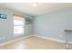 Empty bedroom with blue walls, base molding, and tile flooring at 27941 Austin Woods Dr, Dade City, FL 33525