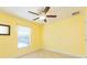 Bright bedroom with a ceiling fan, window and light-yellow-painted walls at 27941 Austin Woods Dr, Dade City, FL 33525