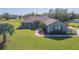 Charming single-story home with a well-manicured lawn, mature palm trees, and inviting front entrance at 27941 Austin Woods Dr, Dade City, FL 33525