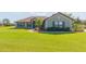 Well-maintained single-story home featuring a lush green lawn and mature landscaping at 27941 Austin Woods Dr, Dade City, FL 33525